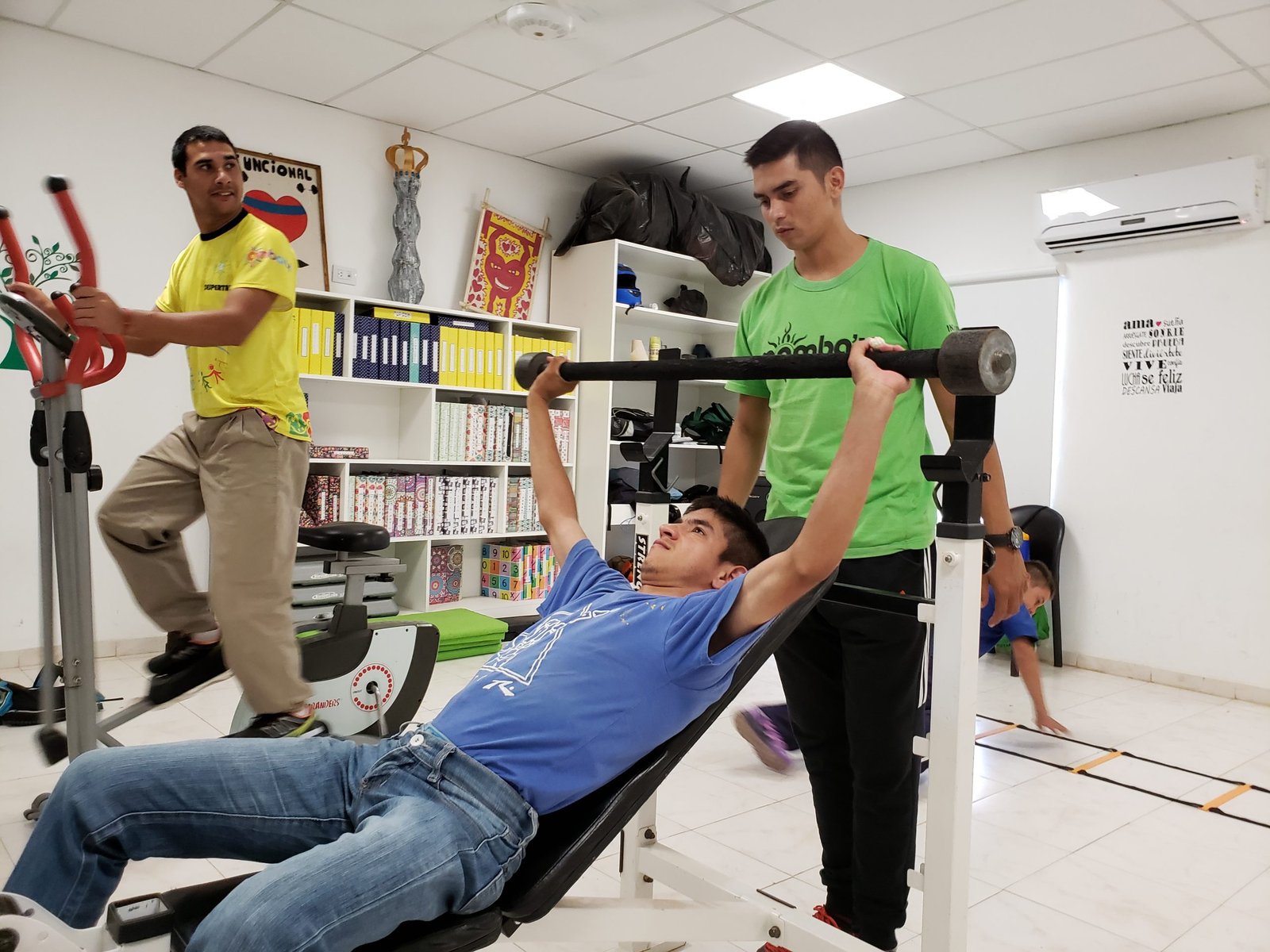 Concurrente entrenando en el gimnasio junto a profesionales